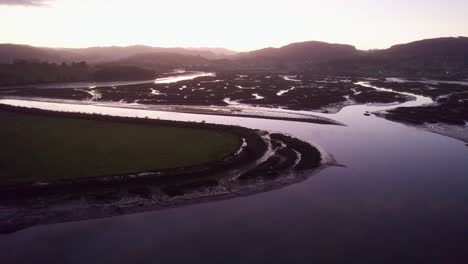 low tide fluvial coastal wetlands mud flat channels at sunset spain aerial 4k