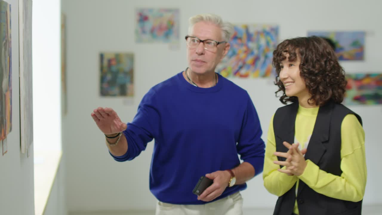 Man and Woman Discussing Artworks in Gallery