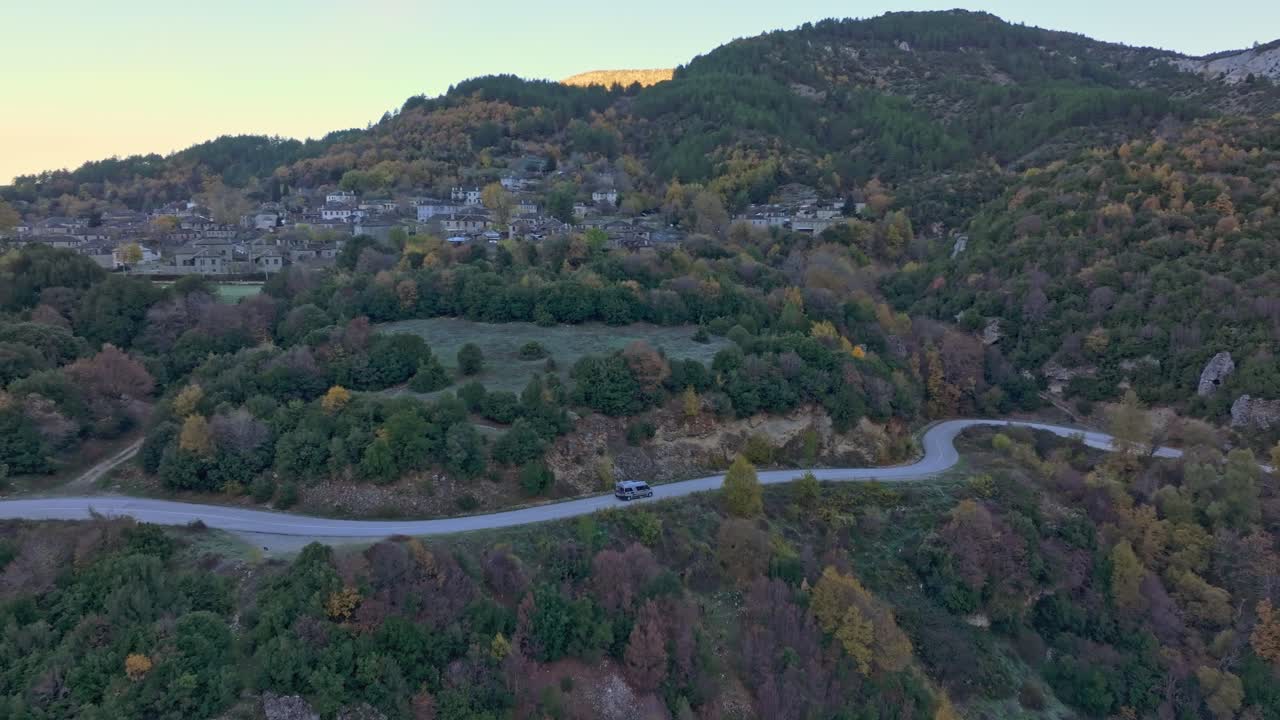 Vue de drone d'un camping-car parcourant une route forestière sous la lumière automnale, Papigo