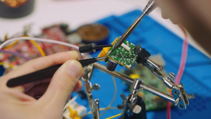 Technician Soldering Electronic Components on Circuit Board