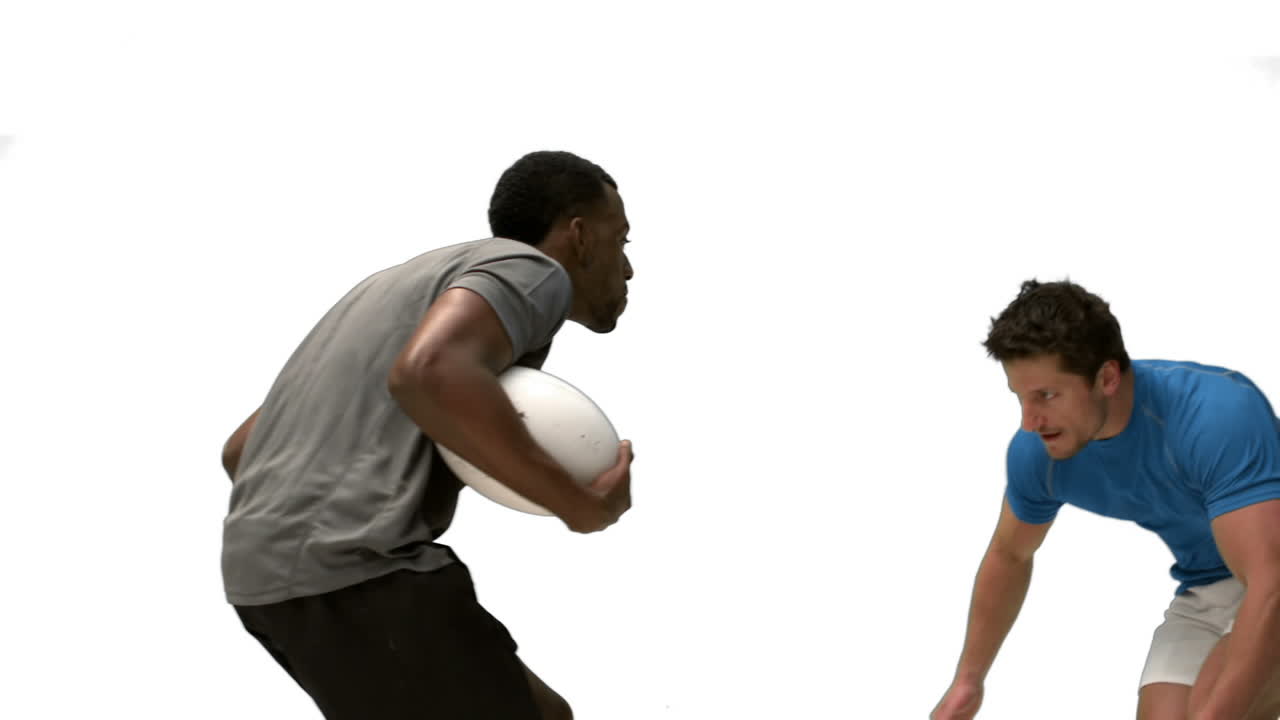 Serious rugby players tackling for ball
