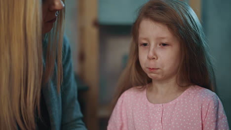 mother gives medicine to little girl suffering from disease