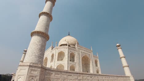 white marble minarets tearing the blue sky around the taj mahal, in agra, india - tilt down static wide shot