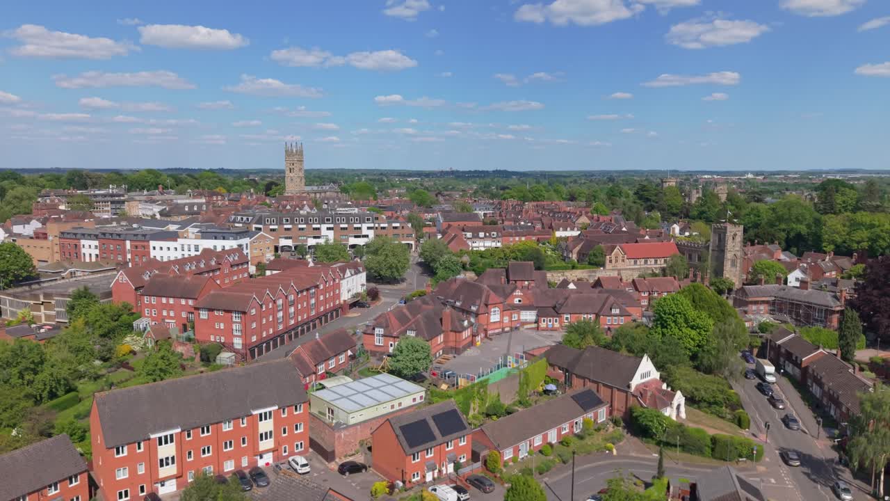 Vista aerea in ascesa con drone del villaggio di Warwick in una soleggiata giornata di primavera, che evidenzia l'architettura tradizionale inglese, la verde campagna e una tranquilla città storica catturata dall'alto