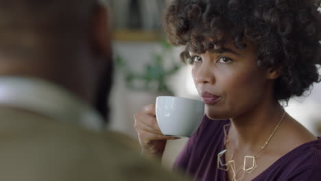 beautiful woman in cafe talking to friend drinking coffee african american female enjoying relaxed conversation chatting together socializing in restaurant shop close up