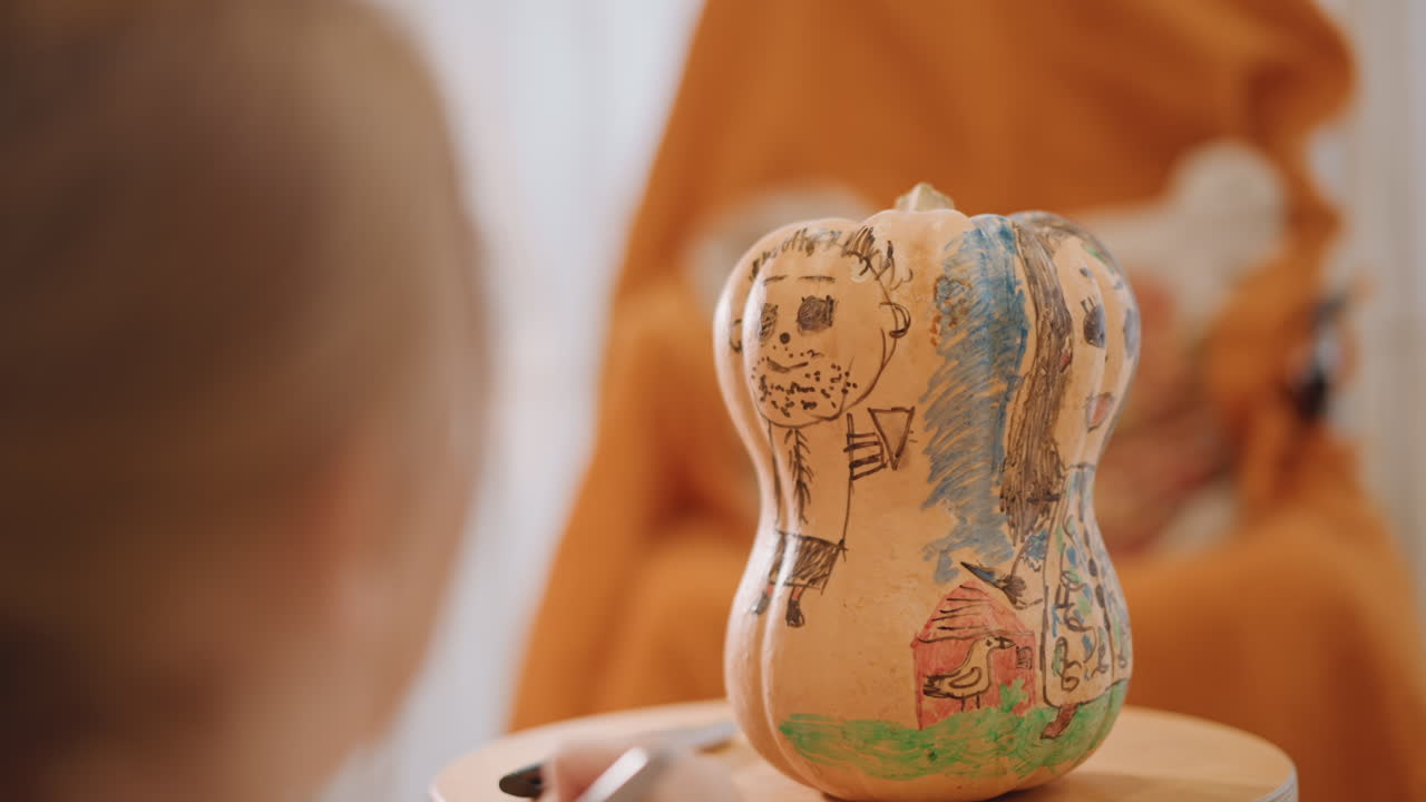 Young girl painting pumpkin gourd, closeup of hands with small brush creating detailed patterns, warm orange blanket backdrop, soft window light, cozy tabletop craft session with palette and careful