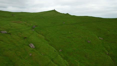 faro de kallur en el prado nebuloso de la montaña kalsoy, islas feroe