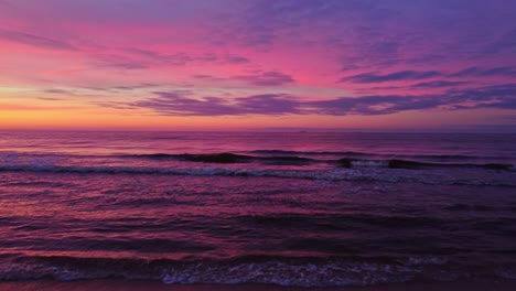 Warm-colors-of-sunset-sky-over-seascape-in-winter-season,-aerial-fly-forward