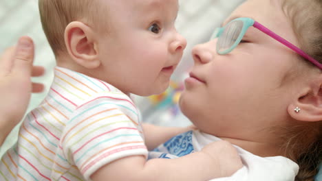 happy sister kissing baby brother