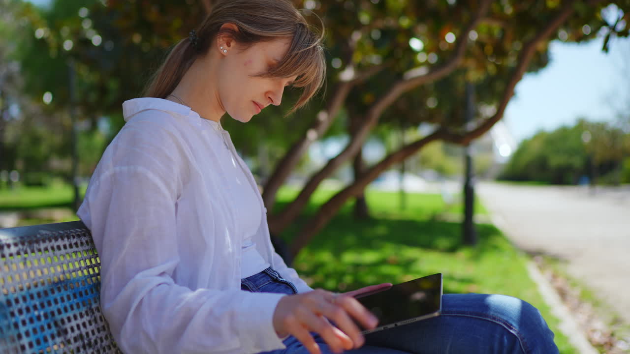mujer usando una tableta en un parque