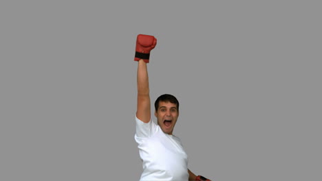 Man-wearing-boxing-gloves-on-grey-screen-