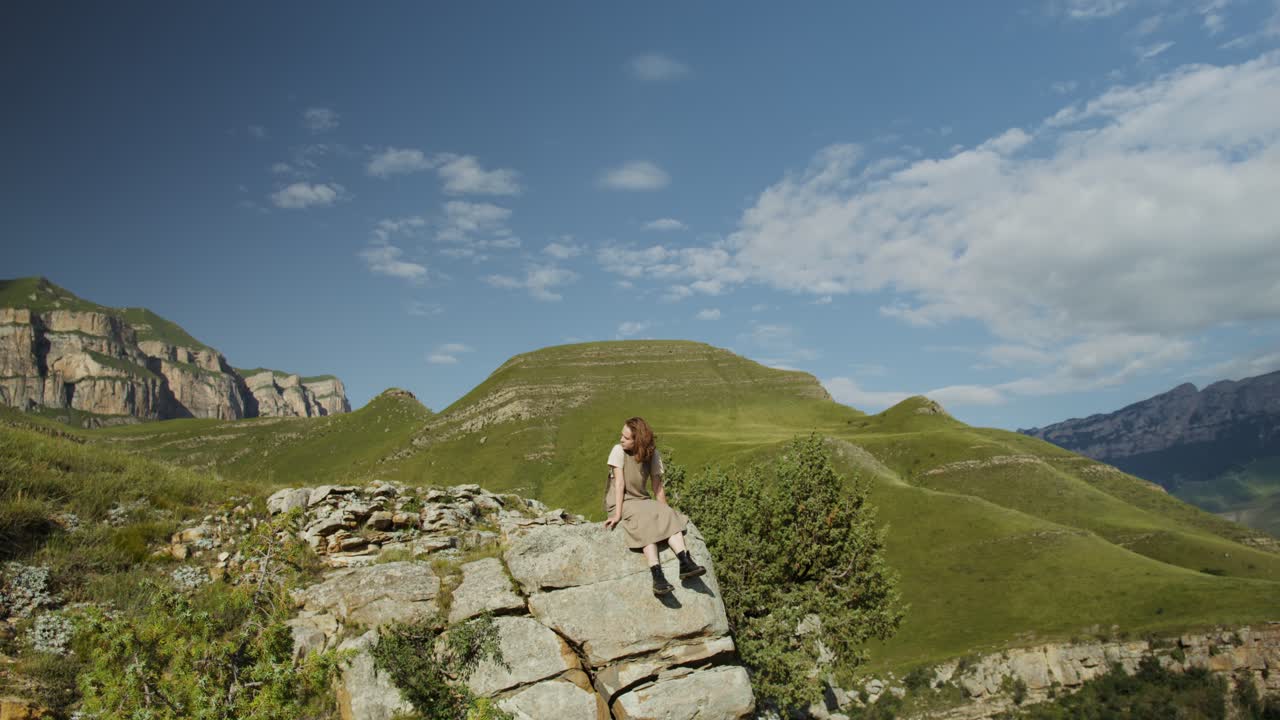 산 꼭대기에 앉아 있는 여자