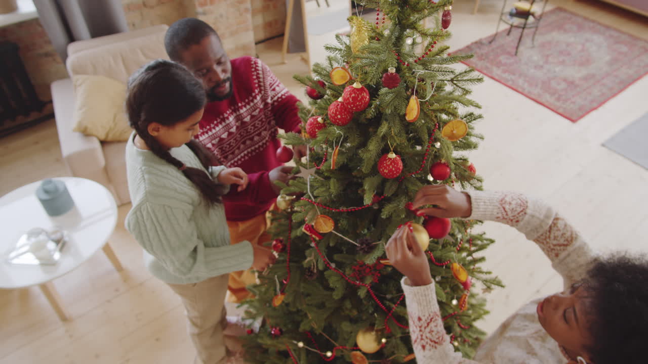 아프리카계 미국인 가족 이 함께 크리스마스 트리를 장식 하고 있다