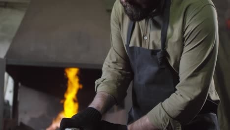 professional blacksmith working with grinder