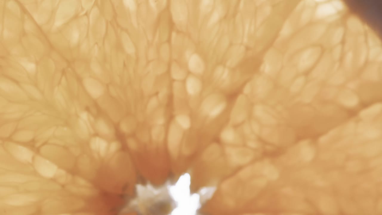 Micro video of close up of slice of orange with copy space