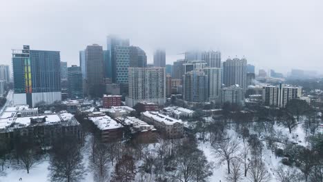 aerial shot pushing in on snow covered buildings in midtown atlanta on january 10th 2025.