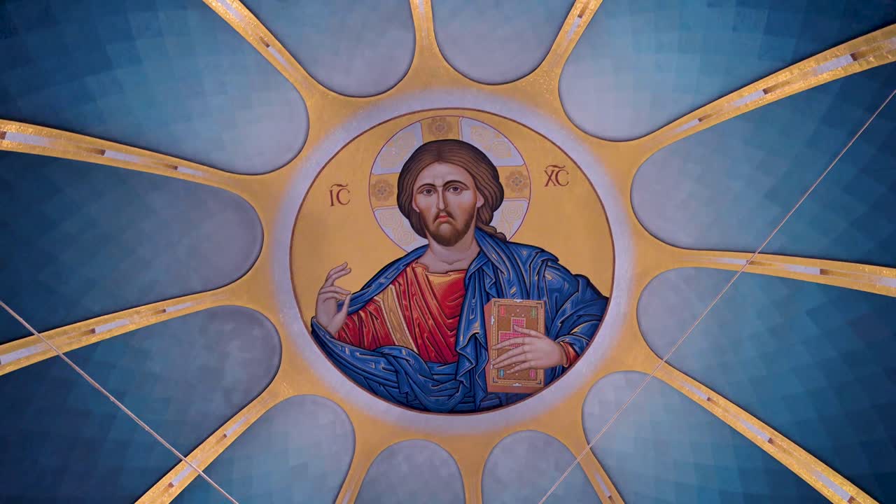 Детальный вид монументальной золотой мозаики, изображающей Иисуса Христа, внутри центрального купола современного православного собора, отличающейся традиционным восточным иконографическим искусством и симметрией.