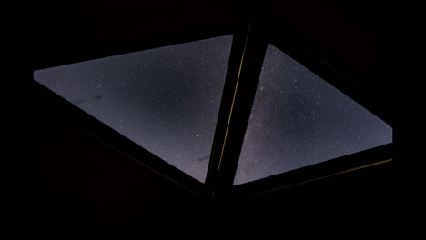 starry night timelapse through modern geometric windows, hotel view looking up
