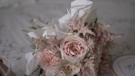 soft focus shot of a blush pink wedding bouquet with delicate floral details on lace fabric
