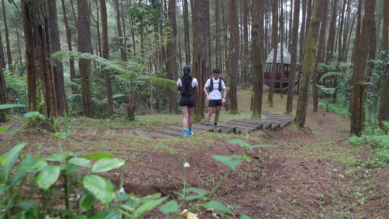 Asian couple taking photos during outdoor adventure in forest