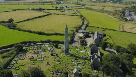 Aerial-view,4K,-Ardmore-Round-Tower-built-in-the-12th-century-and-the-ruins-of-a-Cathedral-dating-from-the-12th-and-13th-centuries