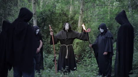 a circle of evil hooded druids in a cult performing a sorcery ritual