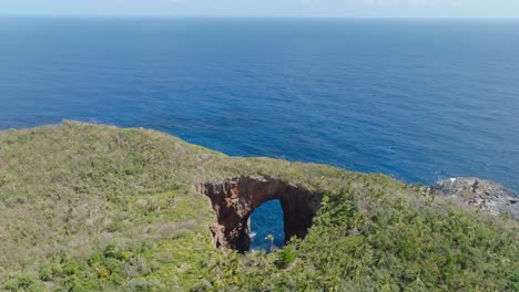 drone flight over cabo cabron nationalpark with arch and blue ocean during sunny day in samana, dominican republic