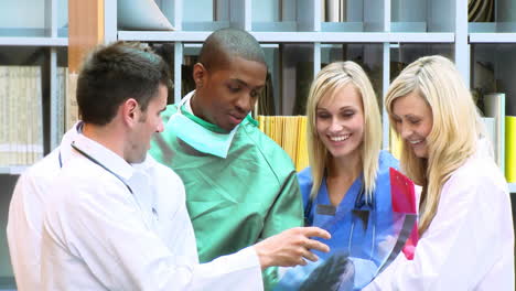 ethnic surgeon and caucasian nurses and doctors examining an xray