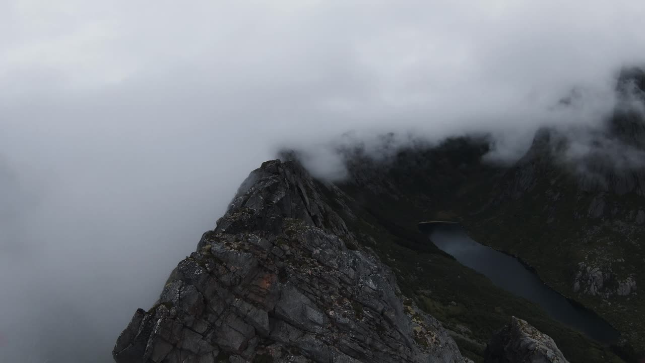노르웨이의 산 능선을 따라 날아가는 왼쪽에는 안개를 통해 볼 수 없고 오른쪽에는 느린 동작으로 계곡의 호수가 보입니다.
