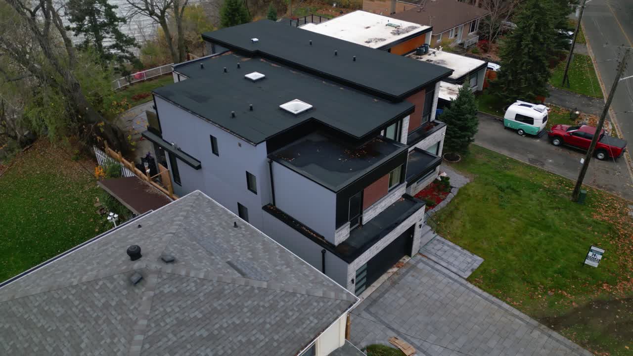 Aerial establishing orbit of a modern home surrounded by greenery, suburban residential design