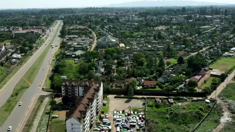 Nairobi-City-with-driving-cars-on-highway-and-green-forest-trees-and-fields-during-sunny-day