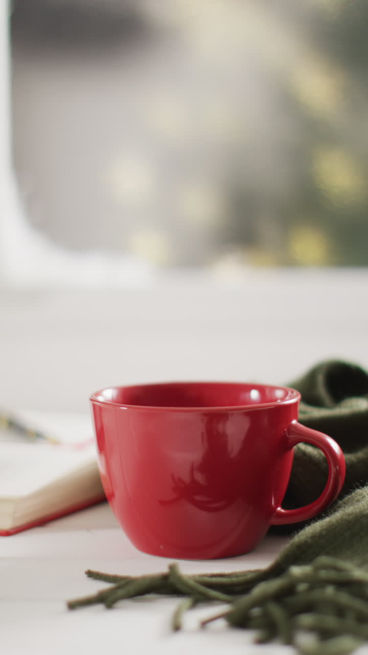 video vertical de una taza de café y un libro sobre el árbol de navidad