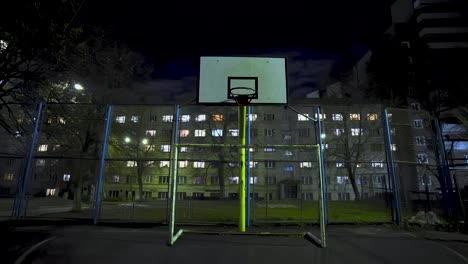 metal mesh. empty basketball court at night in the lights of lanterns. street sport. jail.