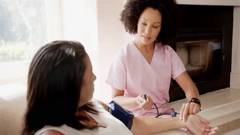 nurse checking blood pressure of patient at home, providing healthcare assistance