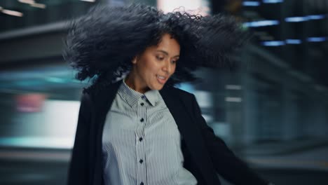 360 degree street shot: cheerful and happy young black woman dancing on the street. african american girl with stylish afro hair having fun, joyfully expressing herself. tracking moving around shot