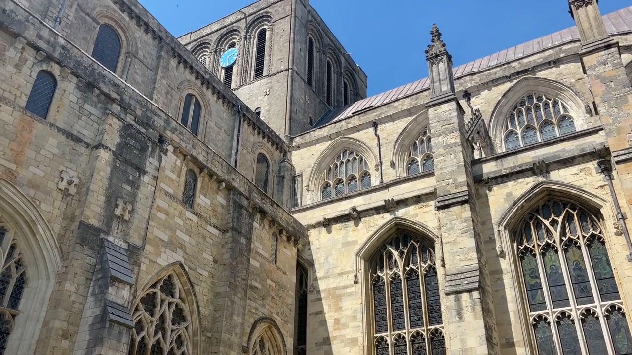 Inquadratura dal basso verso l'alto della Cattedrale di Winchester con finestre gotiche, facciata in pietra storica e architettura medievale a Winchester, Hampshire, Inghilterra
