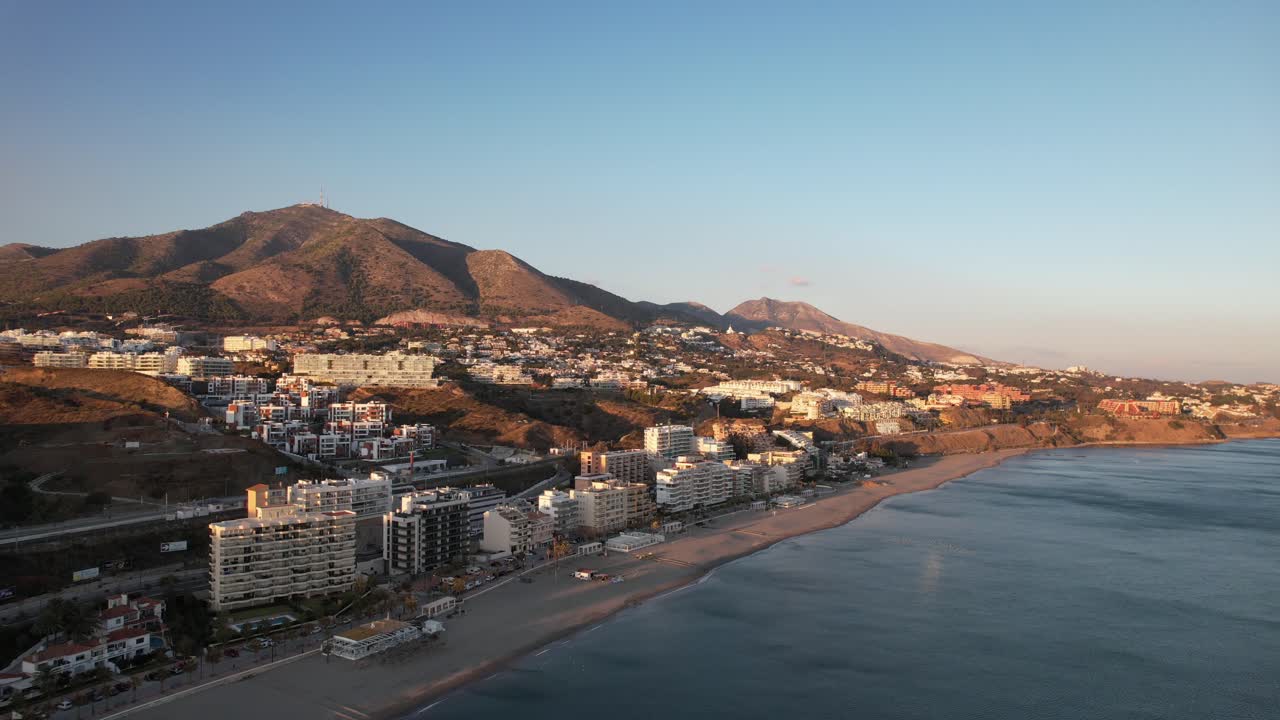 vista costera fuengirola durante la puesta de sol con luz dorada, sierra de mijas montañas en segundo plano