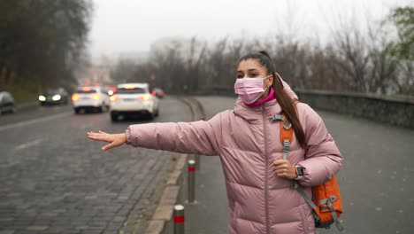 woman waiting for a ride in a city with fog