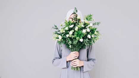 woman in hijab holding a bouquet of flowers