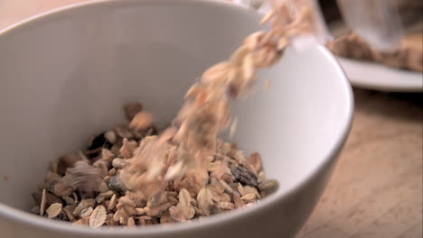 slow motion shot of pouring muesli into bowl