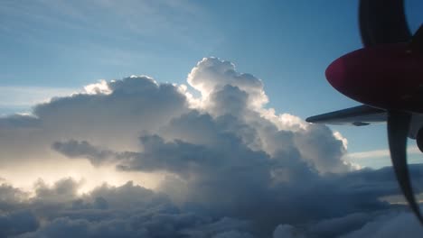 hélice de avión y nubes con sol detrás y algunas vistas del cielo azul desde el ojo de buey