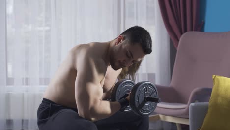 joven que trabaja su cuerpo con equipos de gimnasia en casa.