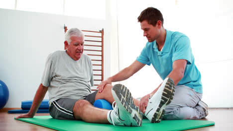 physiotherapist helping patient with his knee mobility