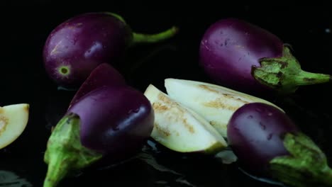 aubergine or eggplants dropped in a puddle of water and solid aubergine