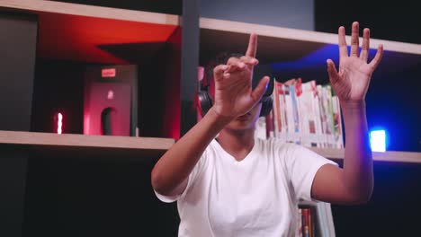 a schoolgirl sitting in front of library's bookshelf and using virtual reality glasses.