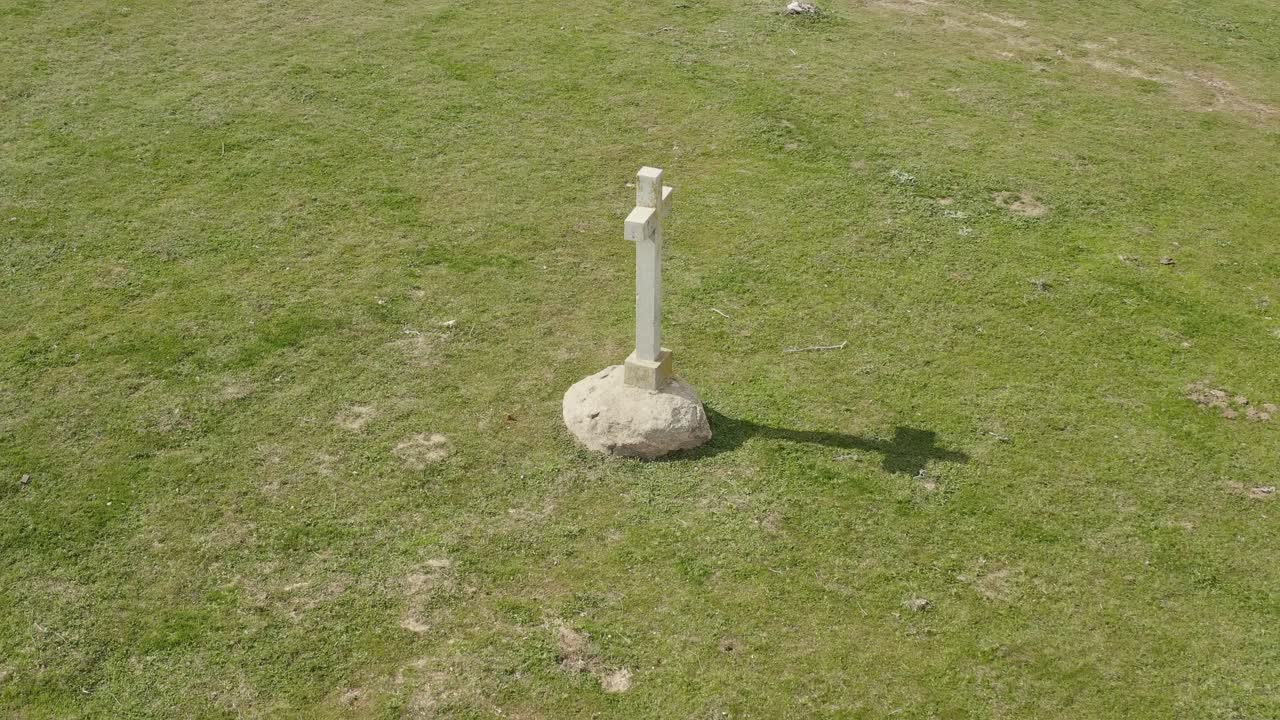 녹색 초원에서  돌 십자가를 공전하는 드론과 함께 고품질의 영상