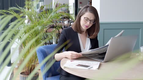 Happy-young-businesswoman-using-laptop-computer-in-a-cafe