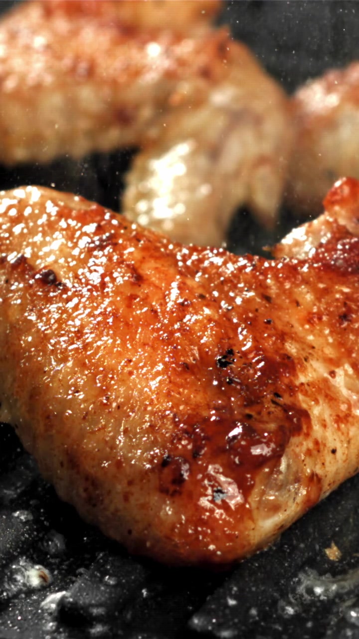 Ala di pollo dorata che sfrigola su una griglia calda