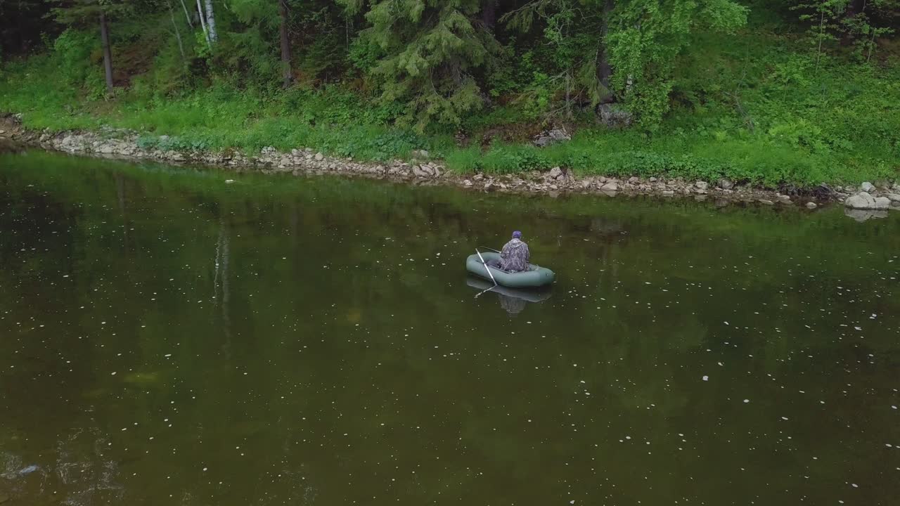 숲 에 둘러싸인 강 에 있는 부풀이 보트 에서 시 하는 사람