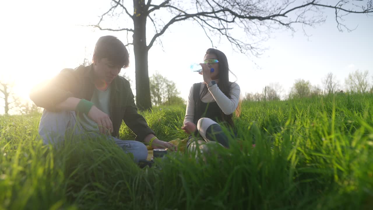 Couple enjoying a picnic in the park at sunset